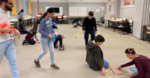Students at the IMC Weekendschool in Amsterdam lay out tracks for a robot.