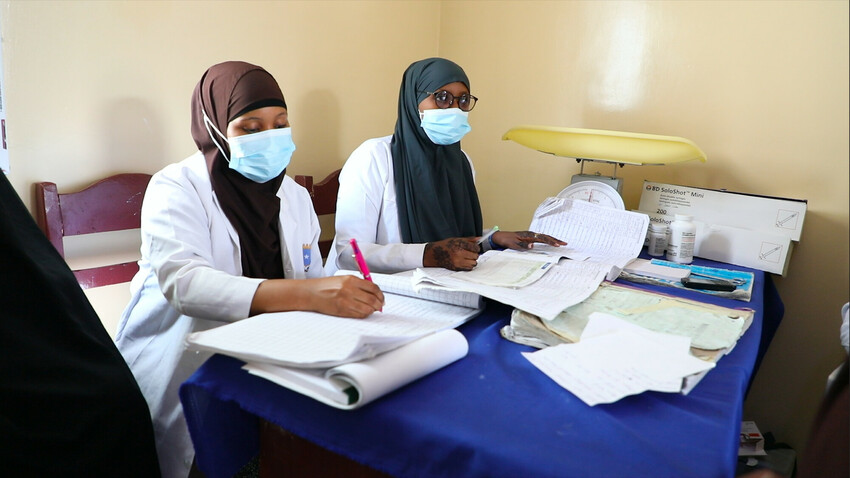 Two nurses in a desk, wearing masks, keeping records at Wadijir Stabilization Centre in Mogadishu.